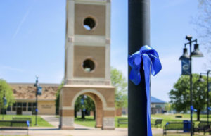 Crowder hangs blue ribbons in the quad to commerate May 2020 graduates.